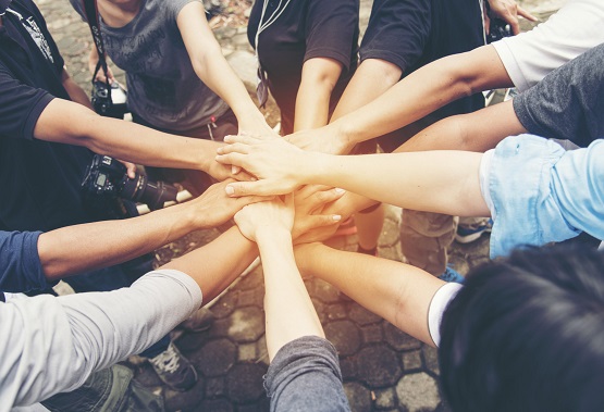 volunteers-overlapping-hands-in-show-of-unity